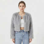 Front view of a model wearing a light grey cropped faux fur jacket.