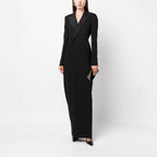 Front full-length studio shot of a model wearing a black double-breasted tuxedo maxi dress.