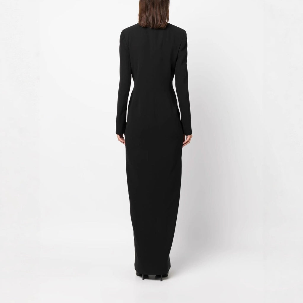 Back full-length studio shot of a model wearing a black double-breasted tuxedo maxi dress.