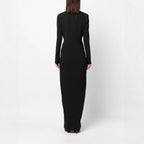 Back full-length studio shot of a model wearing a black double-breasted tuxedo maxi dress.