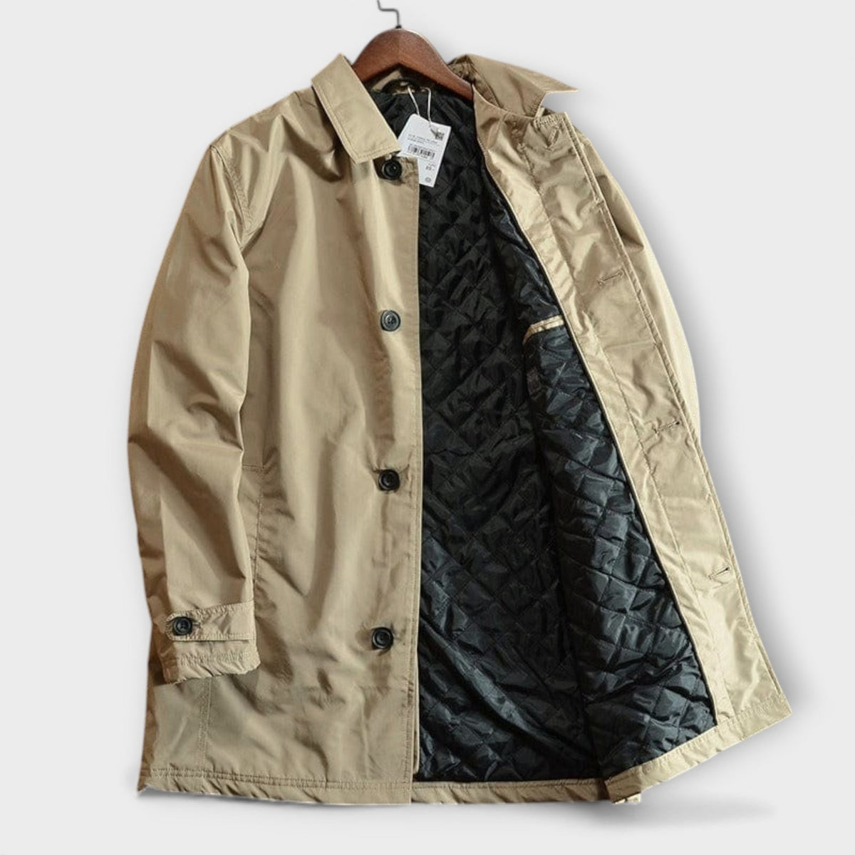 A front view of the open beige trench coat displaying its black quilted interior.