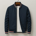 Front view of a navy bomber jacket with red, white, and blue striped ribbed trim, partially unzipped to show a white t-shirt underneath.