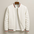 Front view of a white bomber jacket with red, black, and white striped ribbed trim, partially unzipped to show a white t-shirt underneath.