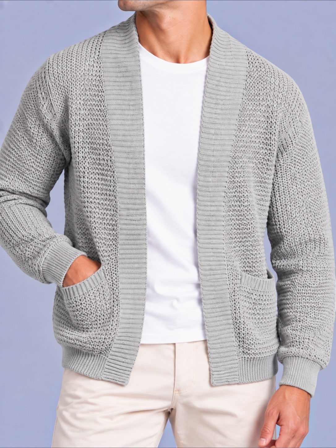 Mid-section front view of a man wearing a light grey waffle knit shawl collar cardigan, showing the open front and pockets.