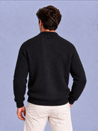 Back view of a man wearing a black waffle knit shawl collar cardigan.