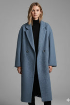 Front view of a woman wearing the blue double-breasted long coat open over a black turtleneck and trousers.