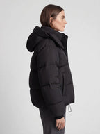 Side profile view of a model wearing the black hooded cropped puffer jacket.