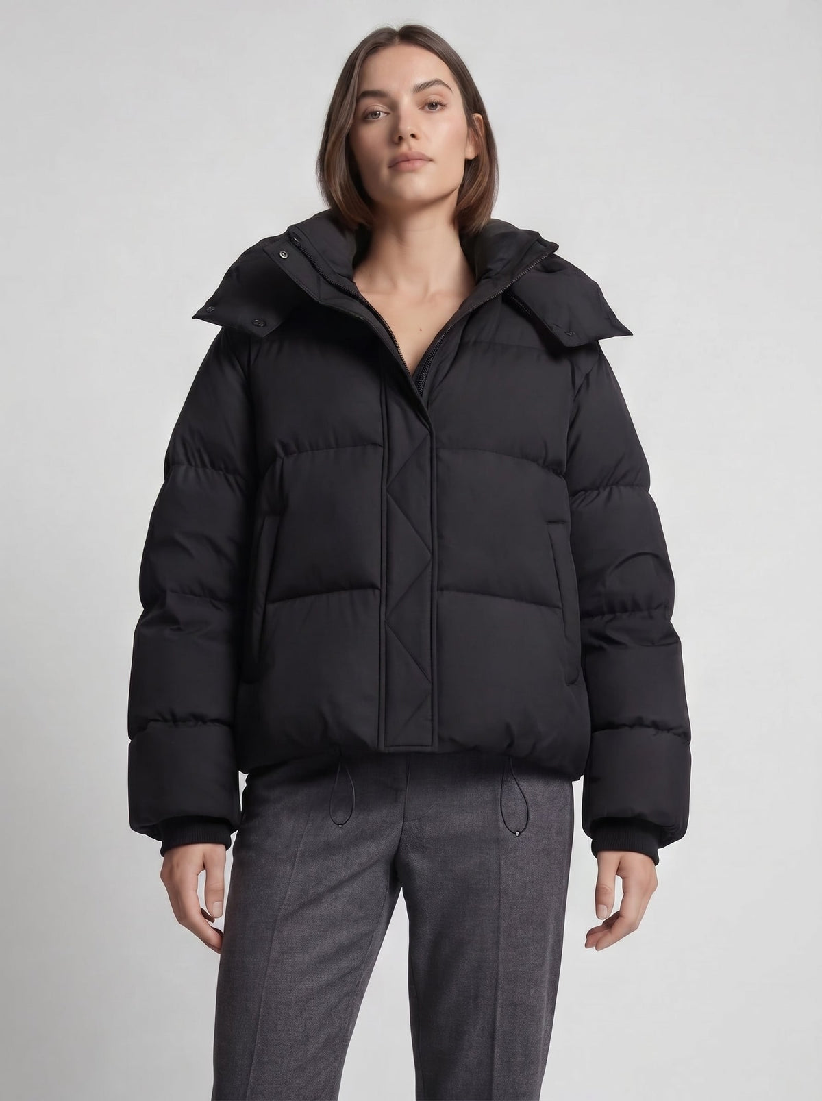 Front view of a model wearing the black hooded cropped puffer jacket, showcasing the fit.