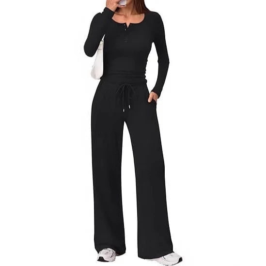 Front view of a woman wearing a black ribbed long sleeve henley top and matching wide-leg lounge pants.
