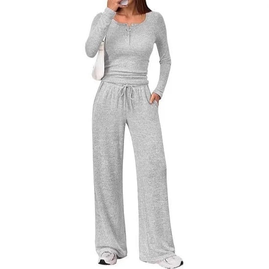 Front view of a woman wearing a light grey ribbed long sleeve henley top and matching wide-leg lounge pants.