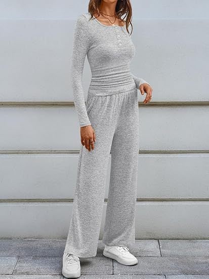 Full body front view of a woman wearing a light grey ribbed long sleeve henley top and matching wide-leg lounge pants outdoors.
