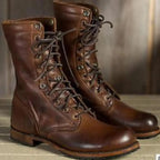 A front view of the pair of brown leather lace-up boots, both standing upright with laces tied.