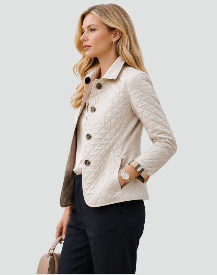 Side view of a woman wearing a cream diamond quilted jacket over a white blouse, with plaid-lined cuffs rolled.
